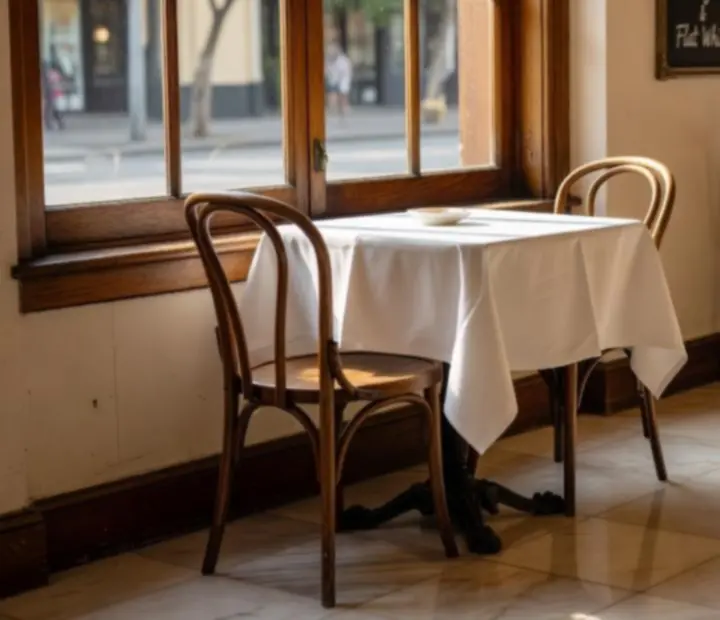 Sunlit bistro window with bentwood chairs and an inviting table at Ranktableevenings.